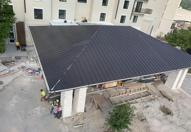 Metal roofing installation team working on a commercial building in Bexley